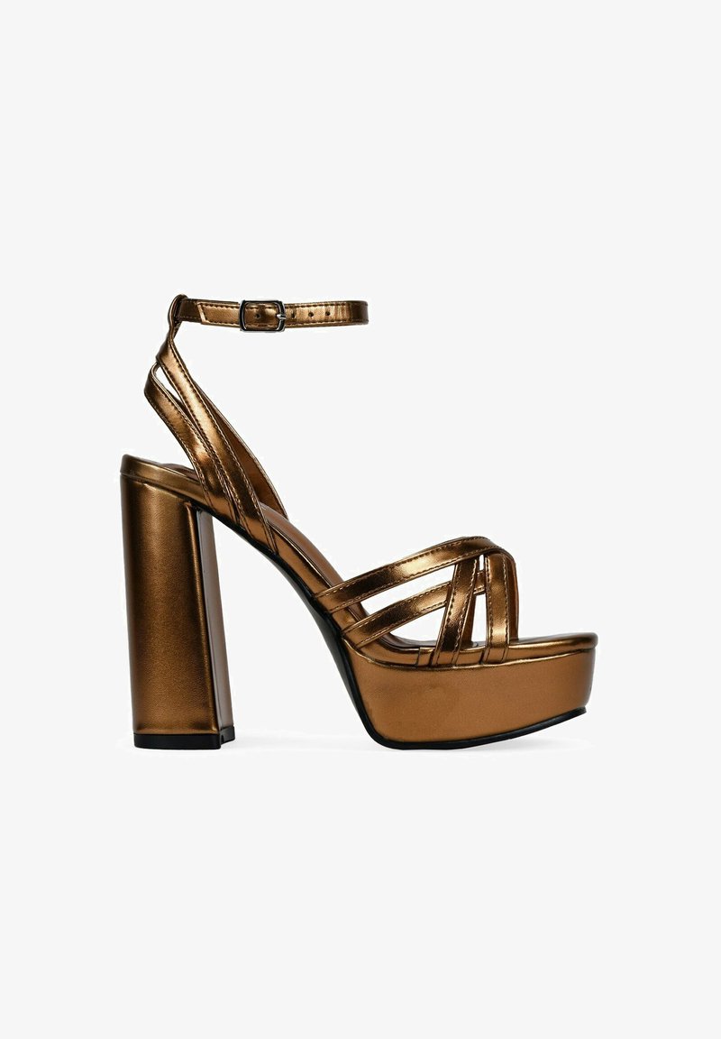 Metallic bronze platform heels with a strappy design, wide block heel, and adjustable ankle strap. Smooth texture and shiny finish.
