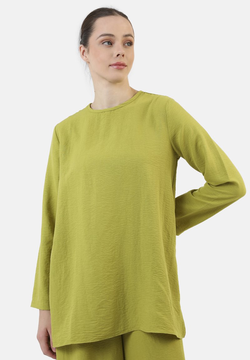 Langærmet, rundhalset top i tekstureret, lys grøn stof. Afslappet pasform med en lige nederste kant. Minimalistisk design uden synlige detaljer.