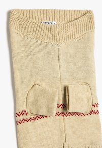 Beżowy sweter z dzianiny z prążkowanym dekoltem, z dwoma małymi kieszeniami i czerwonym wzorem w zygzaku na środkowej części. Miękka tekstura.