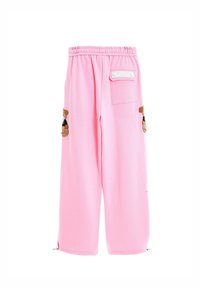 Pantalones de chándal en suave tela rosa, con un corte holgado, bolsillos laterales con aplicaciones de osito de peluche y detalles con cremallera en los tobillos.