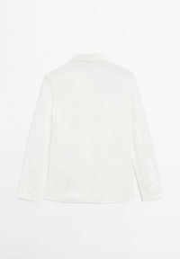 Blouse blanche à manches longues avec une texture douce et lisse, col et poignets boutonnés. Présente un dos simple et épuré sans motifs.