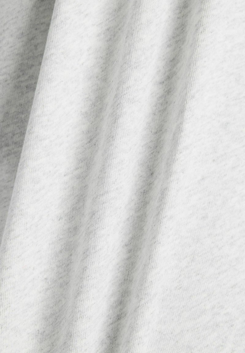 Light grey cotton fabric with a soft, slightly textured surface, featuring smooth folds and a subtle heather pattern.