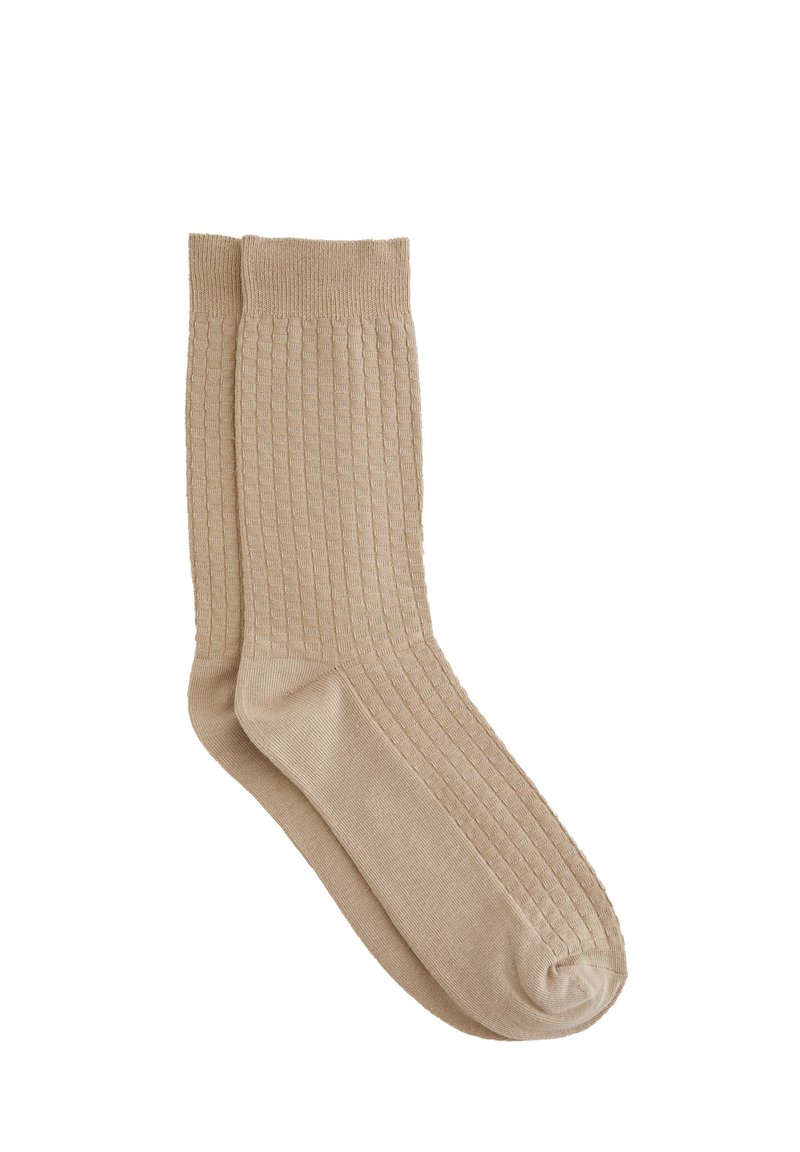 Calcetines de rayas beige con un diseño texturizado, que presentan un puño elástico y una planta suave. Fabricados con material suave y transpirable.