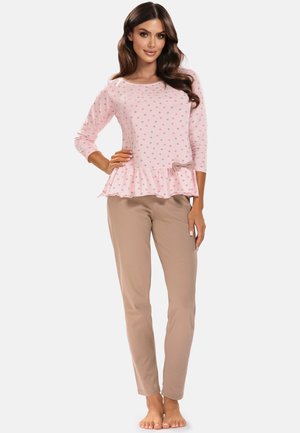 Top da pigiama rosa chiaro a pois con orlo a rouche, abbinato a pantaloni beige uniti. Progettato per il comfort con un tessuto morbido e una vestibilità casual.