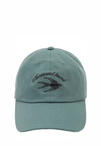 Green cotton baseball cap featuring embroidered "Homeward Bound" text and a swallow design. Curved brim and adjustable strap at the back.