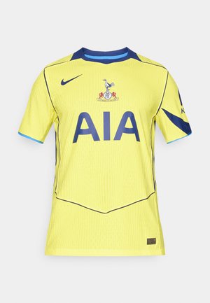 Geel voetbalshirt met korte mouwen, blauwe accenten, ronde halslijn en geribbelde textuur. Bevat het "AIA" logo en het clubembleem aan de voorkant.