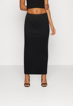 Black ribbed maxi skirt with a fitted design and a smooth texture, complemented by high-heeled strappy sandals.