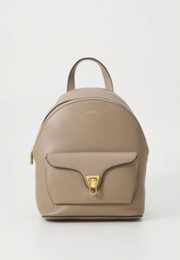 Bež nahrbtnik iz usnja z zaobljeno obliko, zlato obarvanimi kovinskimi dodatki, zgornjim ročajem in sprednjim žepom s poklopcem in zaponko.