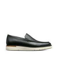 Scarpa slip-on nera in pelle con superficie testurizzata, suola in gomma beige e tacco basso. Presenta un design cucito lungo la parte anteriore.