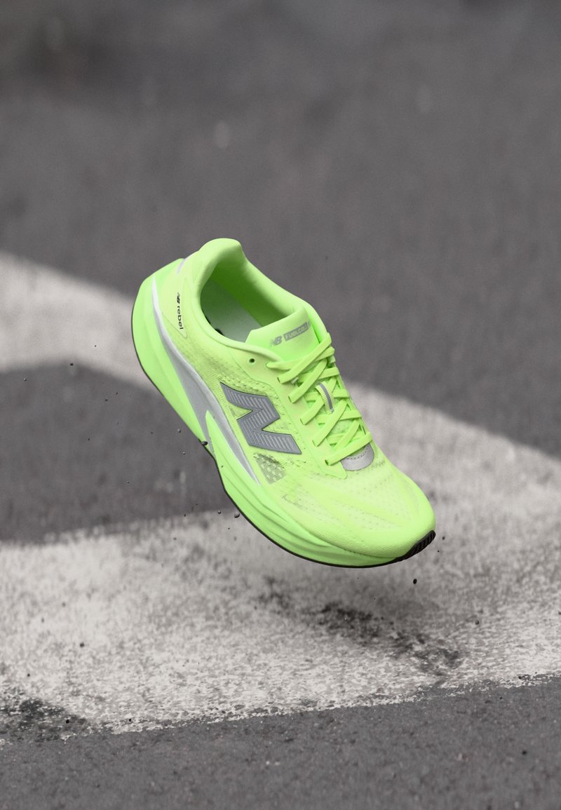 Neon green running shoe with mesh upper, silver accents, and textured sole. Features lacing system and lightweight design.
