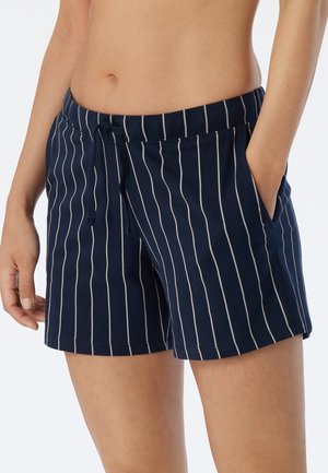 Mörkblå bomullsshorts med vita vertikala ränder, dragsko i midjan och sidofickor. Slät textur med en avslappnad passform.