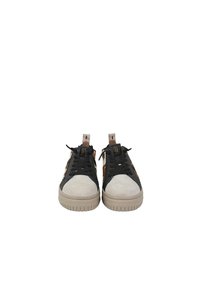 Sneaker neri e beige con punta in suede, pannelli laterali testurizzati e lacci neri piatti; suola in gomma beige con scanalature orizzontali.