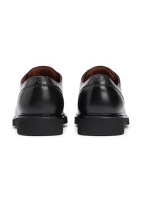 Μαύρα δερμάτινα παπούτσια με στρογγυλεμένη μύτη, επίπεδη σόλα και μινιμαλιστικό σχεδιασμό. Διαθέτουν διακριτικό λογότυπο στη φτέρνα και λιτή, γυαλιστερή επιφάνεια.