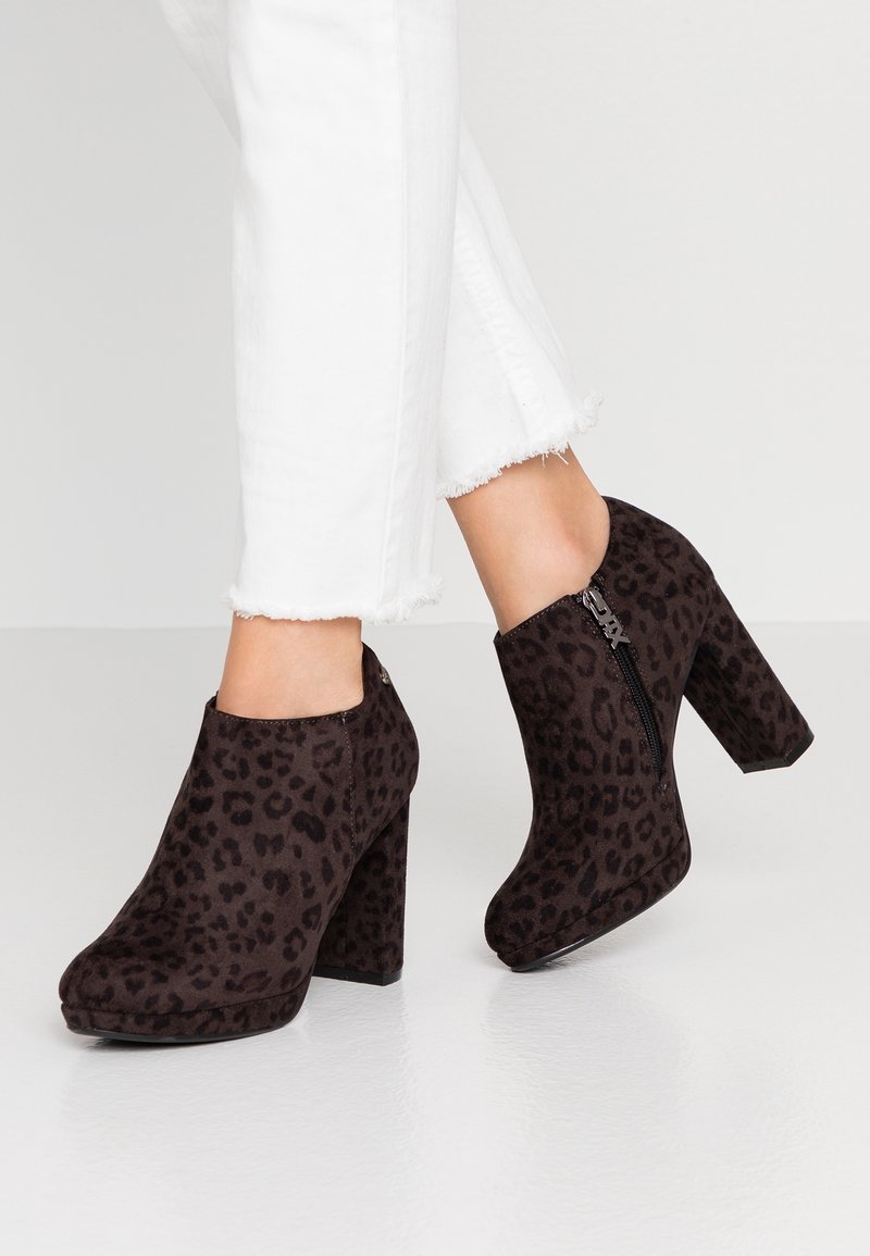 Černé kotníkové boty s leopardím vzorem, s vysokým blokovým podpatkem, polstrovanou platformou a bočním zipem. Vyrobené z materiálu připomínajícího semiš.