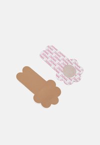 Two paper pieces in various shapes: one in brown with a smooth texture, and another in white with pink text reading "MAGIC" in a repeated pattern.