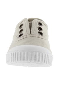 Canvas sneakers i beige med en tekstureret overdel, to sæt snørehuller og en hvid gummisål med et rillestruktur.