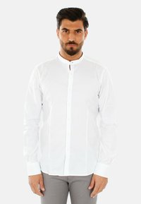 Camicia bianca a maniche lunghe con colletto band, chiusura frontale con bottoni e una texture liscia. Presenta polsini stretti e un design slim fit.