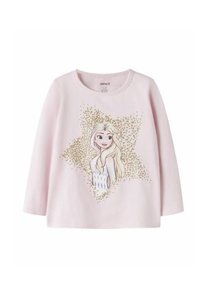 Chemise rose clair à manches longues avec une princesse dessin animé en robe blanche et cheveux blonds longs, entourée de points pailletés dorés en forme d'étoile.