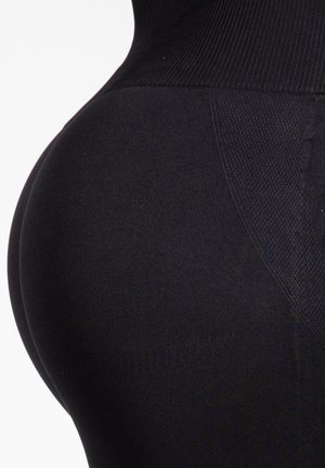 Zwarte leggings met een struktureel ontwerp, dat de gladde, aansluitende vorm benadrukt. Voorzien van rekbaar materiaal en een brede tailleband voor comfort.