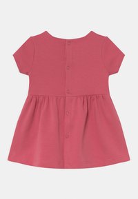 Sukienka z krótkim rękawem z jednolitej różowej bawełny z marszczoną spódnicą i zapięciem na guziki z tyłu. Gładka faktura i okrągły dekolt.