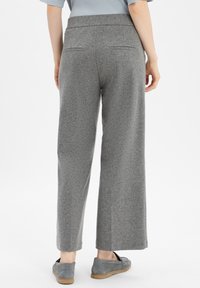 Grau weit geschnittene Hose aus weichem Stoff mit glatter Textur, ausgestattet mit zwei Gesäßtaschen und einem flachen Bunddesign.