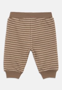 Καφέ παιδικό παντελόνι με οριζόντιες λευκές ρίγες, ελαστική μέση με ριμπ ύφανση και ριμπ μανσέτες στους αστραγάλους.