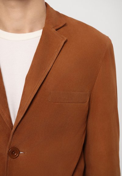 Brown suede blazer with a single button closure, notch lapel, and a chest pocket. The fabric has a smooth texture and matte finish.