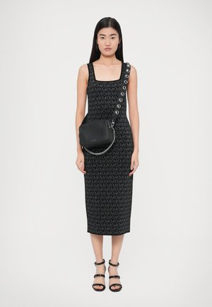 Robe midi en maille noire avec un col carré et un motif répétitif de logo. Associée à un petit sac noir et des sandales noires à lanières.