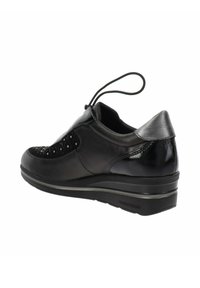 Zapato de cuero negro con acentos texturizados, acabado suave y un tacón modesto. Presenta un cordón para ajuste y detalles perforados en el lateral.