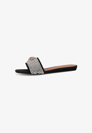 Zwarte slideslipper met een band versierd met strass-steentjes en een decoratief accent. Zacht suède materiaal met een platte zool en een open ontwerp.