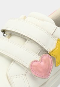 Λευκό αθλητικό παπούτσι με δύο αυτοκόλλητους ιμάντες Velcro· διαθέτει ροζ καρδιά και κίτρινα αστέρια εφαρμογές· απαλό δερμάτινο υλικό· στρογγυλεμένο σχήμα.