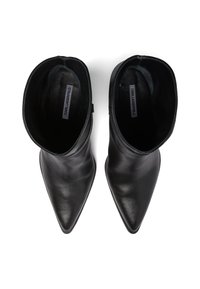 Črne usnjene gležnjarje s koničastim nosom in gladko teksturo. Imajo ukrivljeno obliko in minimalističen dizajn z notranjimi oznakami.