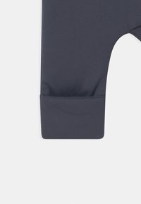 Leggings en coton bleu marine avec une texture douce, dotés d'un poignet de cheville ajusté et d'un design simple et épuré.