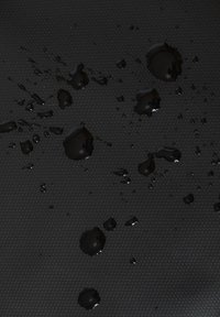 Superficie nera texturizzata con gocce d'acqua sparse, che evidenziano le proprietà impermeabili del materiale.
