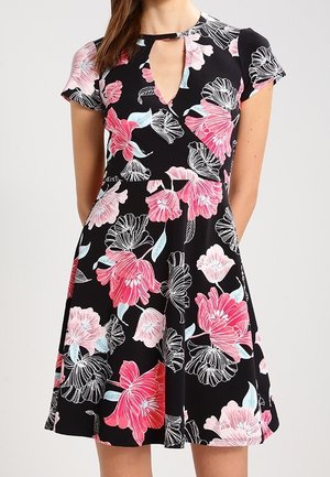 Černé šaty s krátkým rukávem s růžovým, bílým a světle modrým květinovým vzorem, s výstřihem ve tvaru klíčové dírky a přiléhavým pasem.