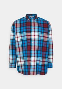 Camicia a quadri con bottoni, caratterizzata da una combinazione di colori blu, rosso, bianco e marrone, con colletto e maniche lunghe. Tessuto morbido con motivo a scacchi.