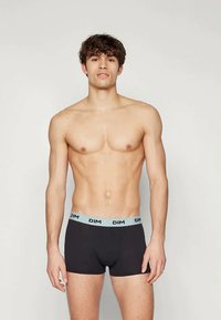 Μαύρα μποξεράκια με ελαστική μέση σε απαλό μπλε χρώμα με το λογότυπο "DIM". Λείο ύφασμα, εφαρμοστή σχεδίαση και μεσαίο ύψος.