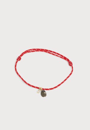 Bracciale in corda rossa intrecciata con due piccoli ciondoli d'oro, uno a forma di palla spinata e l'altro una gemma trasparente.