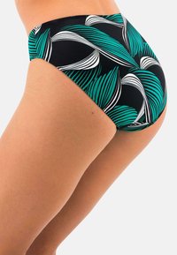 Spodní část plavek z černé látky s zeleno-bílým vzorem listů. Vysoký pas, hladký povrch a tvar s plným krytím.