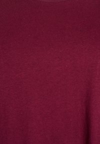 T-shirt bourgogne en tissu doux et texturé avec des copeaux subtils. Encolure ronde classique et manches courtes. Pas de motifs ou d'accents visibles.