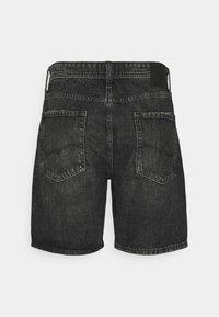 Pantalones cortos de mezclilla negra con corte recto, que cuentan con dos bolsillos traseros y una superficie texturizada. La cinturilla incluye una etiqueta de tela.