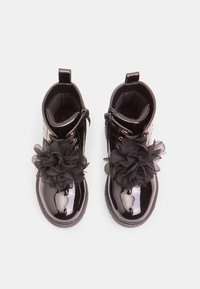 Czarne lakirowane botki za kostkę z teksturowanym kwiatowym detalem, złotymi elementami i bocznym zamkiem błyskawicznym dla łatwego zakładania. Okrągły przód.