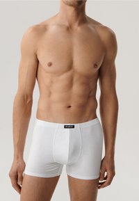 Białe bawełniane bokserki z czarnym pasem, na którym widnieje napis "ATLANTIC", charakteryzujące się dopasowanym krojem i gładką teksturą.