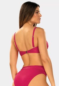 Różowy zestaw bikini z żebrowanej tekstury, regulowanymi ramiączkami i metalowymi akcentami. Wysokie majtki mają gładkie wykończenie.