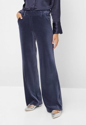 Pantalons en velours côtelé bleu marine à jambe large avec une finition texturée, dotés de poches latérales et d'un devant plat. Assortis à des ballerines argentées à bout pointu.