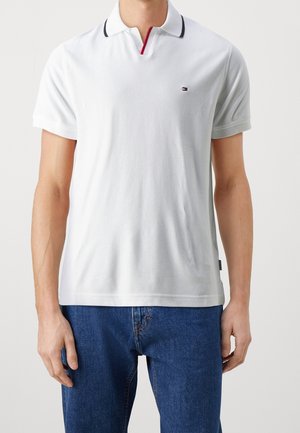 Polo-Shirt i hvidt bomuld med korte ærmer, med en kontrasterende sort krave og rød detalje, lille logo på brystet, afslappet pasform.