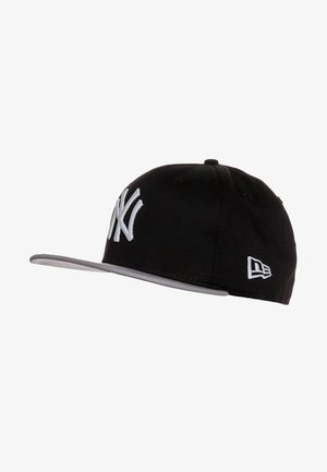 Casquette de baseball noire avec un logo "NY" blanc à l'avant et un bord de visière gris, avec un petit logo New Era blanc sur le côté.