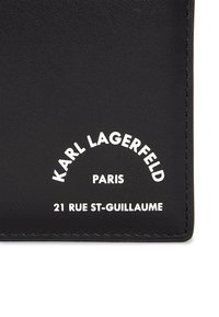 Portofel din piele neagră cu text alb embossat: "KARL LAGERFELD PARIS" și "21 RUE ST-GUILLAUME." Textura netedă cu colțuri rotunjite.