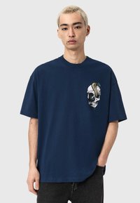 Granatowy bawełniany t-shirt z krótkimi rękawami, z kolorowym nadrukiem czaszki i węża na piersi. Luźny krój z okrągłym dekoltem.