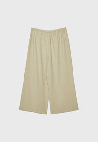 Pantalons larges beige avec une taille élastique, fabriqués en tissu texturé, présentant une coupe décontractée et un design longueur cheville.
